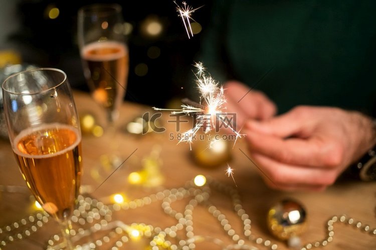 男人拿着火花和香槟玻璃新年派对