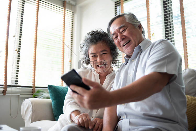 快乐亚洲老年夫妇使用智能手机.