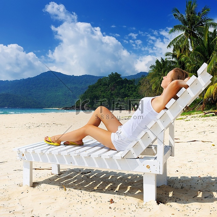 热带海滩上的女孩坐在沙发休息室