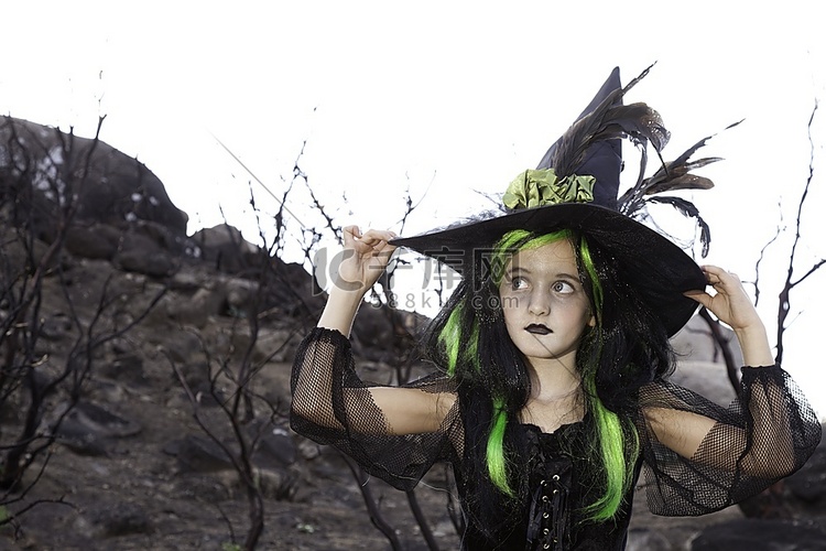 漂亮的小女巫戴着女巫帽子，看向
