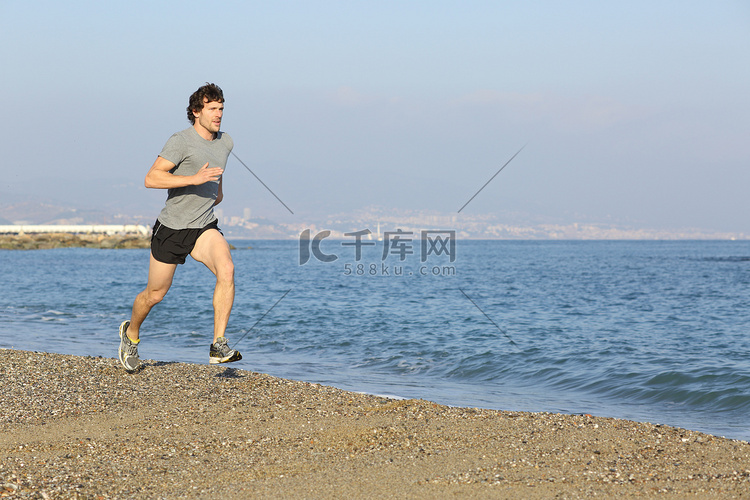 慢跑者在水附近的海滩上运行