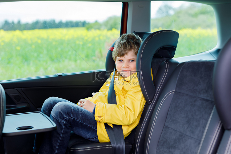 可爱可爱的学龄前孩子男孩坐在车