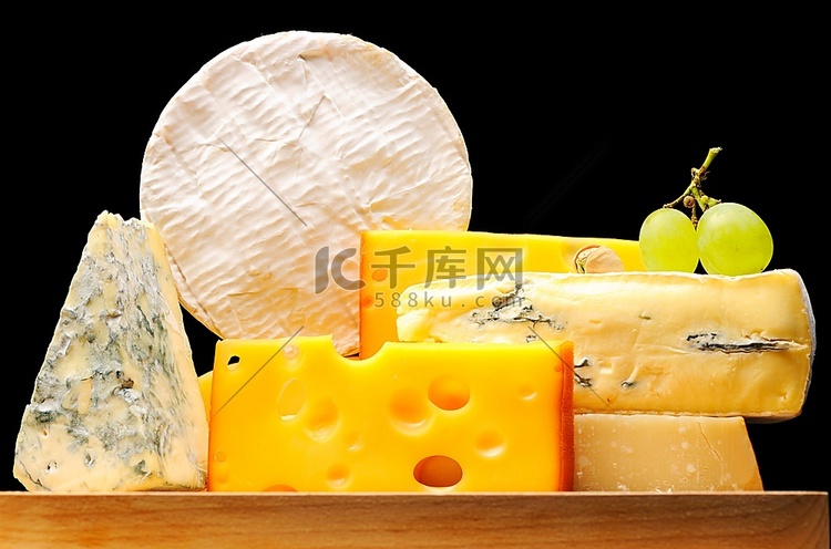 各种类型的奶酪覆盖在黑色之上
