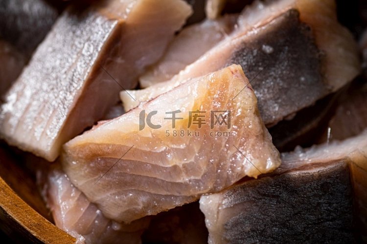美味的咸鲱鱼片在一块石板。黑色