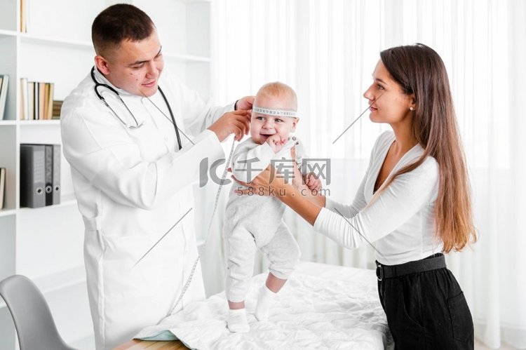 母亲抱着婴儿，而医生看着它
