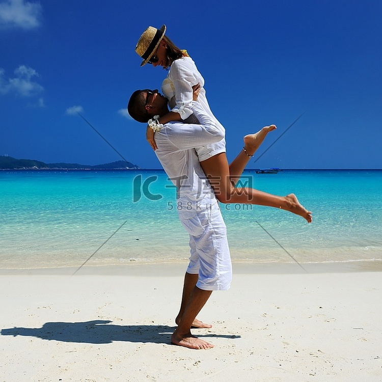 热带海滩上的一对白衣情侣