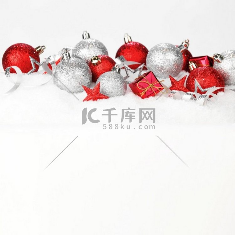 红色和银色圣诞球和装饰在雪。圣
