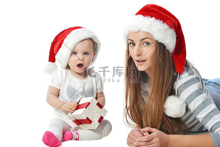女婴和妇女在圣诞老人帽子与圣诞