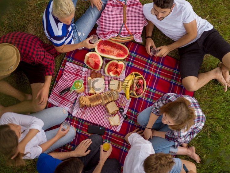 一群年轻的朋友享受野餐时间饮料