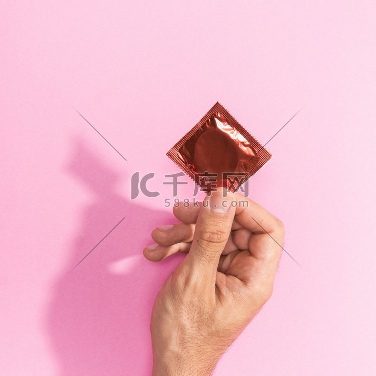 一名男子举着红色避孕套