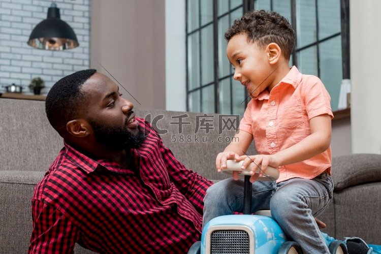 黑人小男孩和父亲一起开玩具车