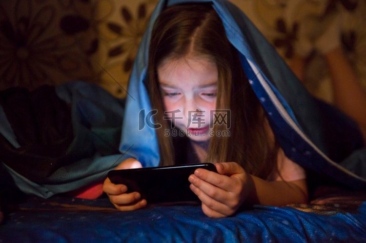 女孩玩智能手机游戏暗室
