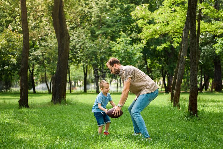 父亲和儿子在公园玩美式橄榄球