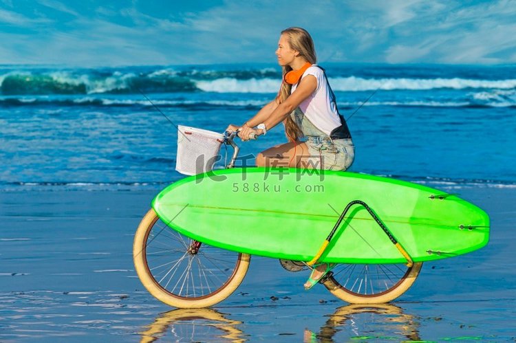 海滩上骑着冲浪板和自行车的年轻