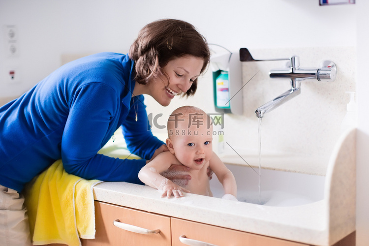 Mother bathing baby in hospital room