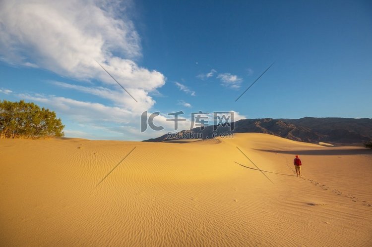 沙漠中的徒步旅行者。日出时间。