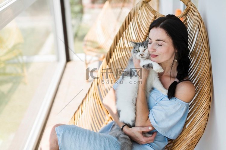 年轻女子坐在椅子天井爱她的宠物