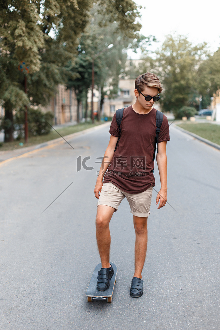 戴太阳镜的年轻帅哥骑在滑板上.