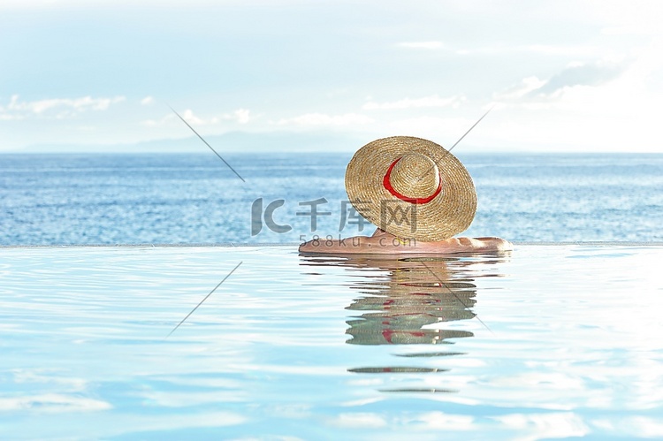 戴着帽子的女人在游泳池里放松