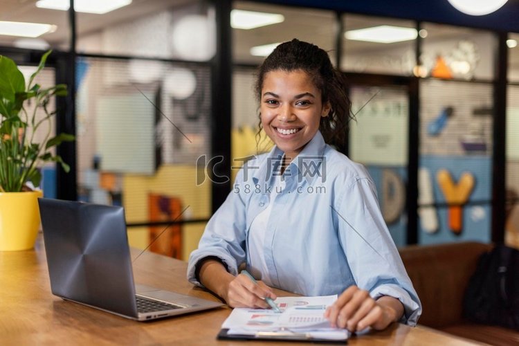 微笑的女人工作与笔记本电脑文件