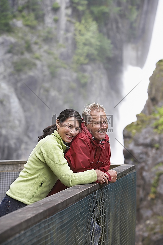 男人和女人看着瀑布附近的景色，