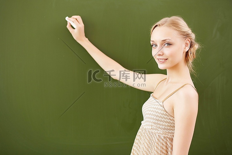 站在学校黑板旁的年轻女教师