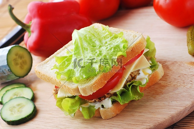 夹着肉排和蔬菜的三明治放在盘子