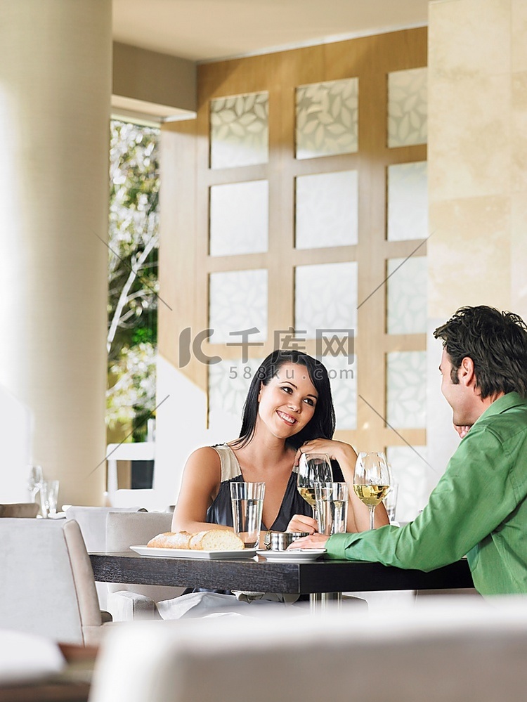 一对情侣在户外餐厅边喝酒边聊天