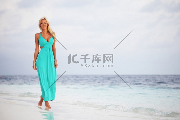 一位穿着蓝色连衣裙的女人在海边