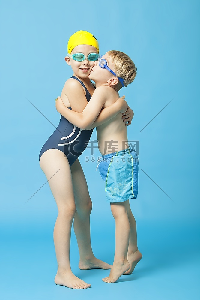 穿着泳衣的小兄弟姐妹在蓝色的背
