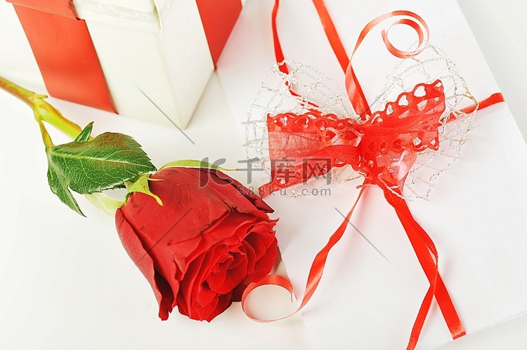 美丽的红玫瑰和带丝带的字母特写