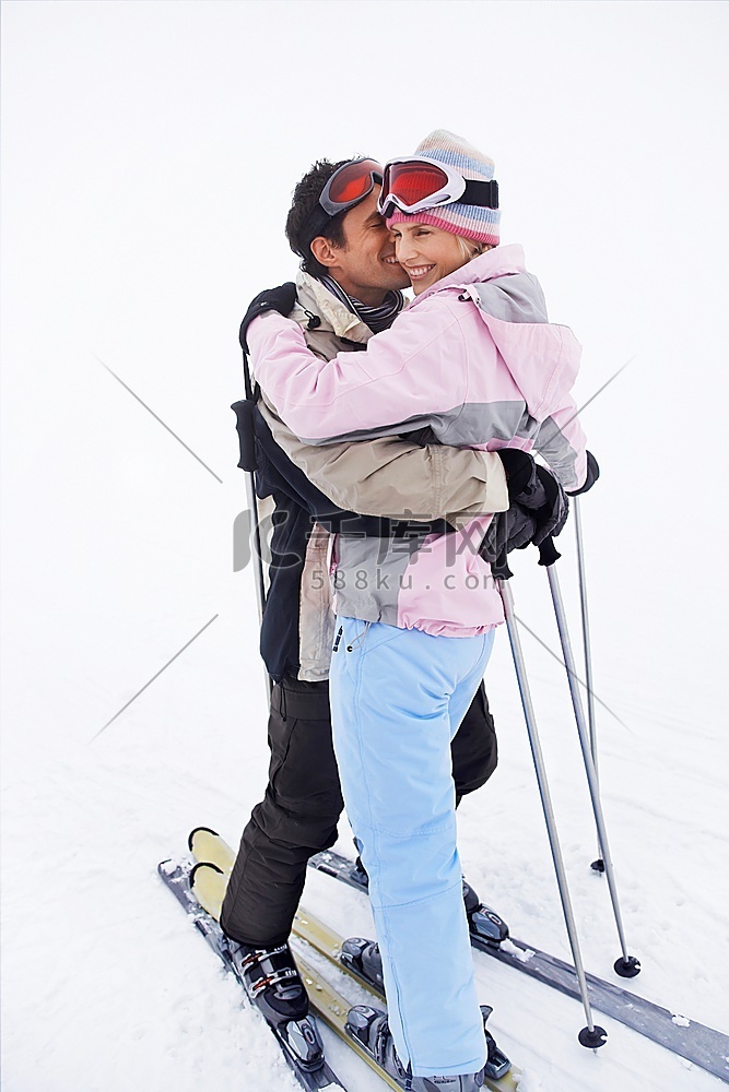 一对情侣站在滑雪道上拥抱