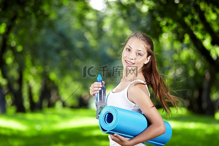 女孩与一瓶水和体操垫转