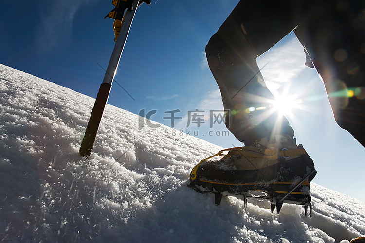 登山者：带冰爪和冰斧的靴子上的