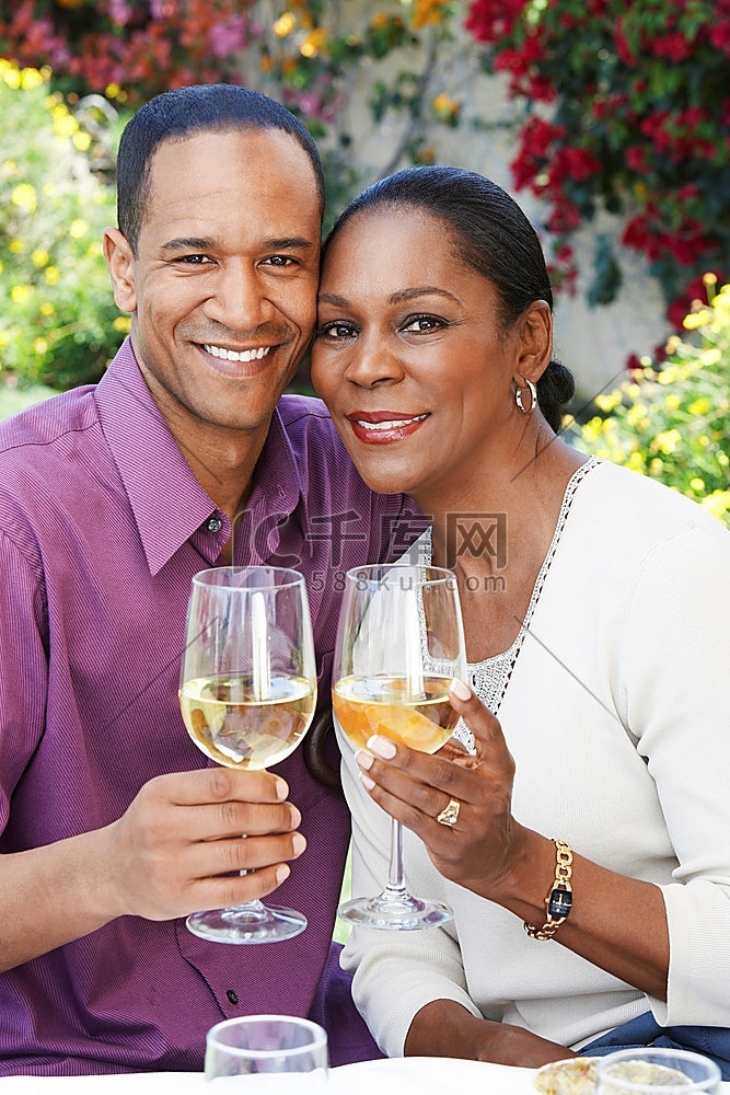 幸福的情侣在外面喝着一杯白葡萄