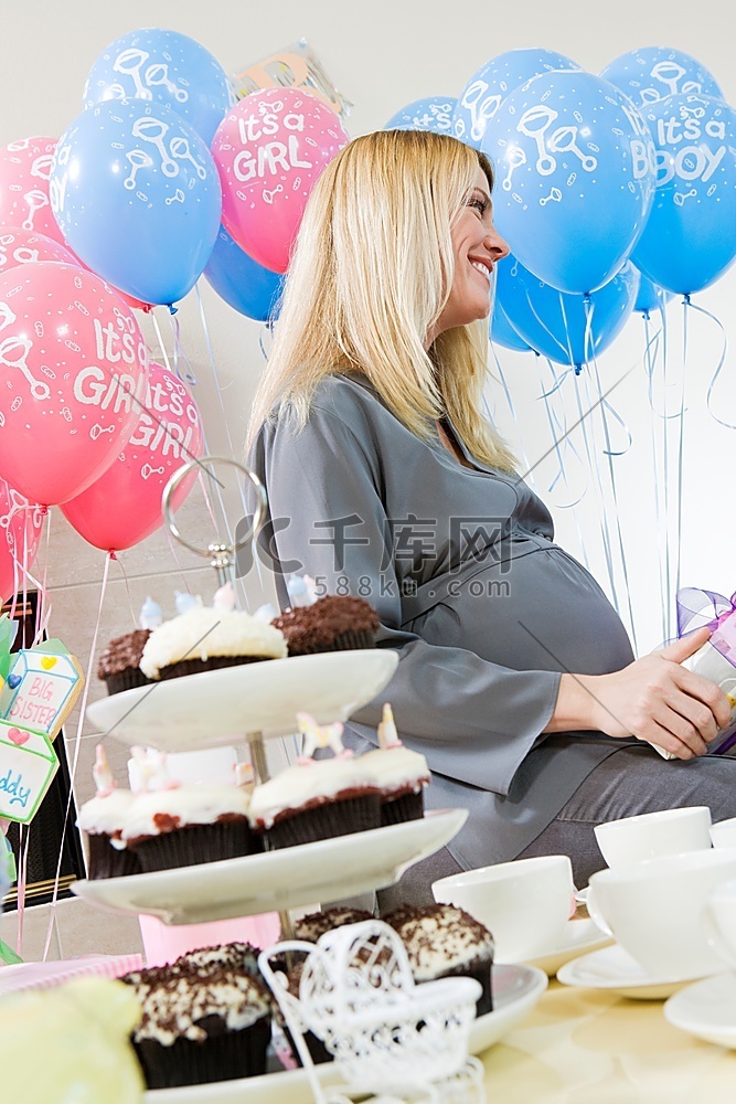 孕妇在婴儿送礼会上坐下来