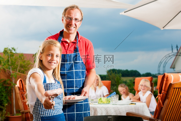 快乐的一家人在夏天烧烤；父亲和