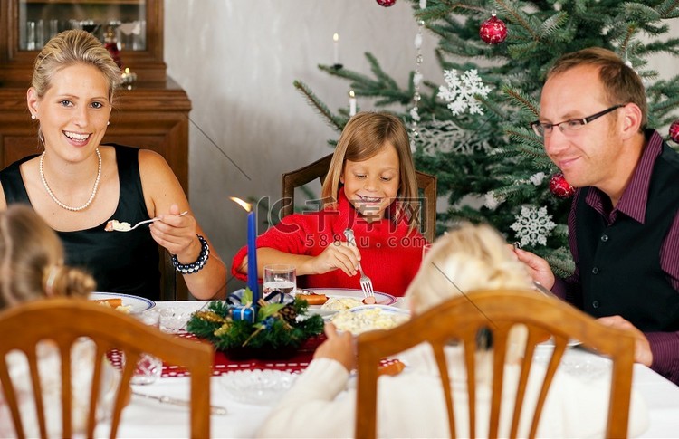一家人在圣诞树前吃传统的圣诞晚