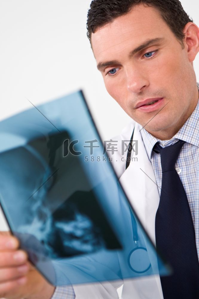 一名男医生在检查人体头骨的X光