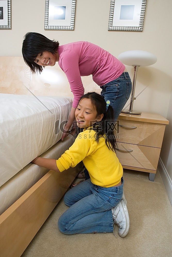 一名中年妇女和她的女儿在铺床