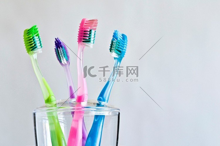 四种不同颜色的牙刷放在牙刷架上