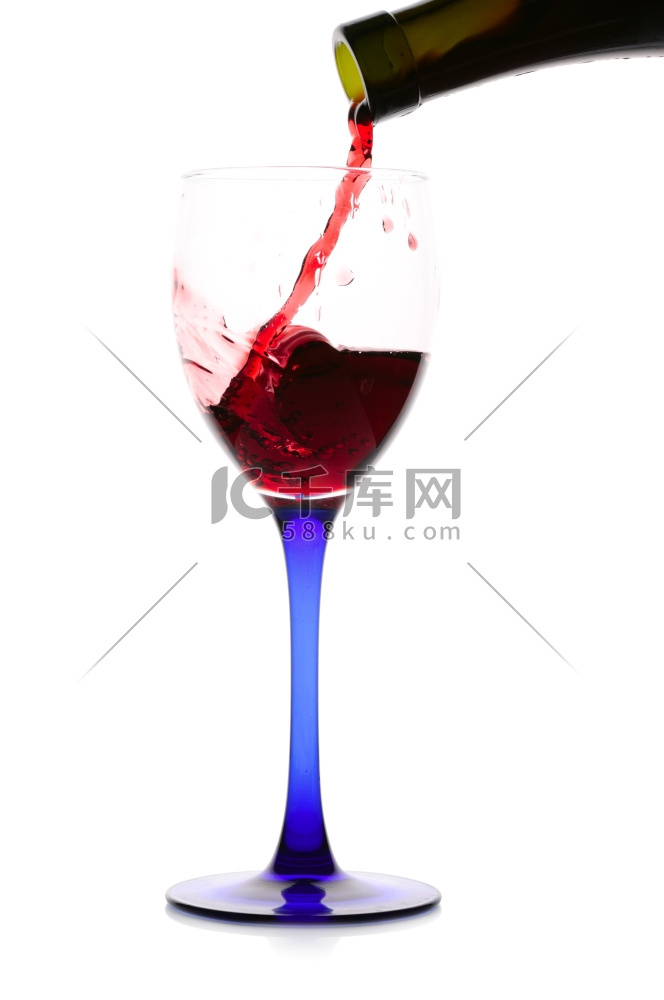 红酒从绿色的瓶子流到玻璃杯里。