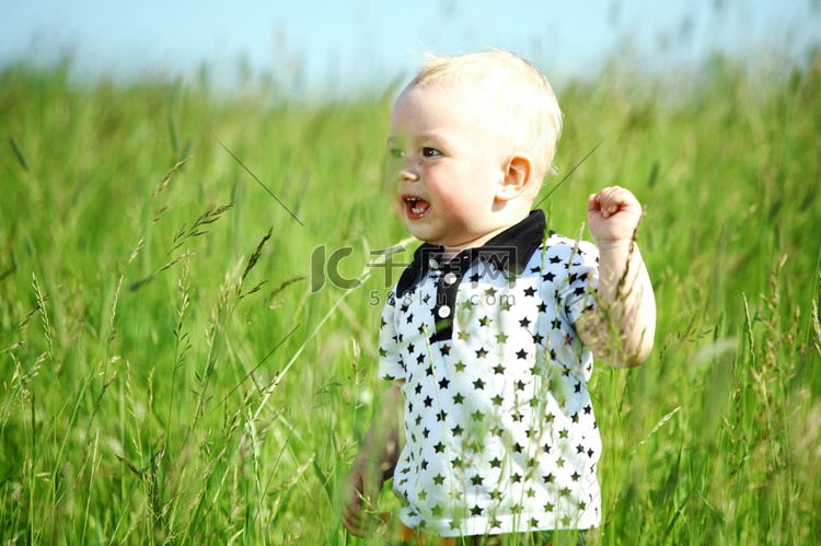 小男孩在绿色的草地上玩耍