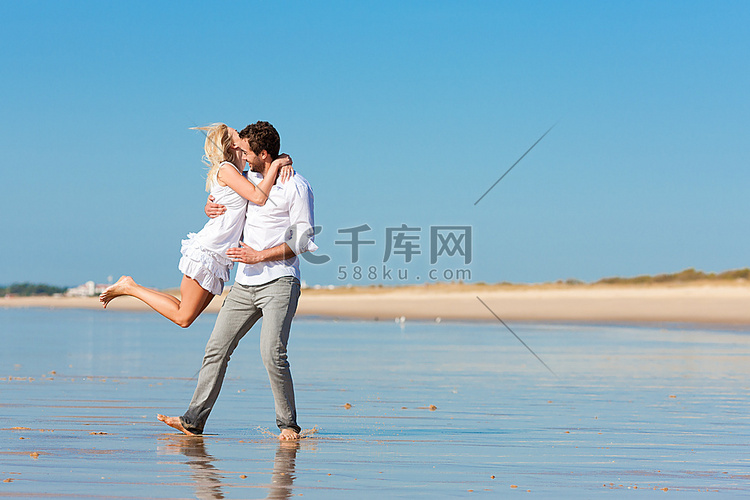 海滩上的一对穿着白色衣服的夫妇