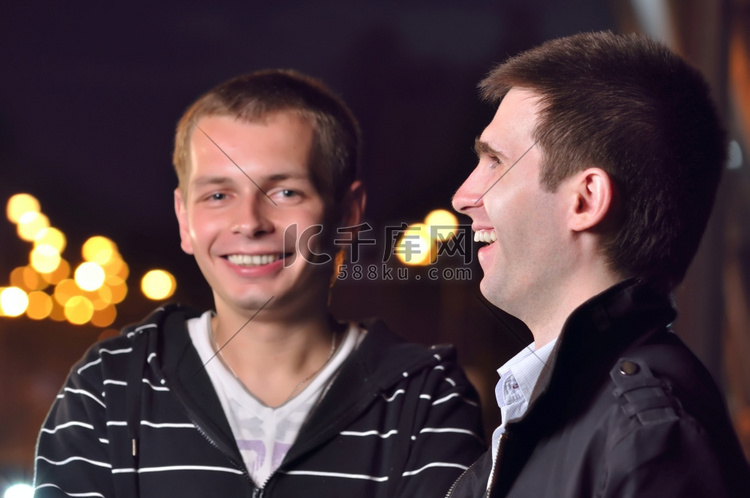 两个朋友笑在夜城市街道