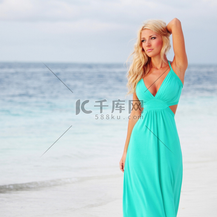 一位穿着蓝色连衣裙的女人在海边