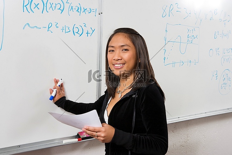 女学生在白板上写数学方程式