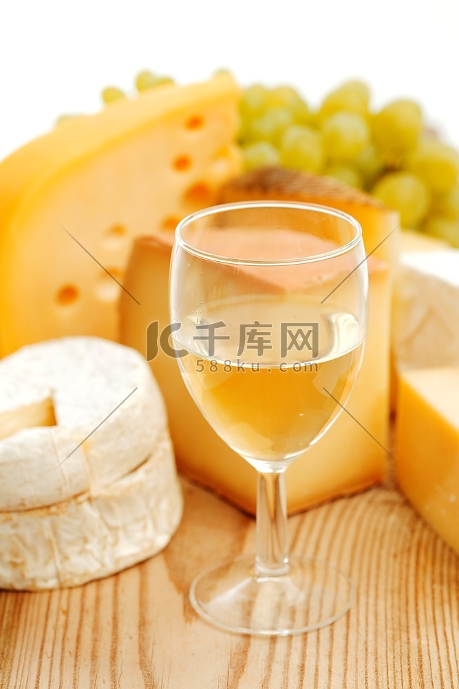 在木桌上放着奶酪和葡萄酒