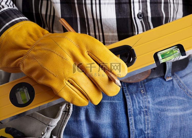 手的建设者与黄色的保护手套和水