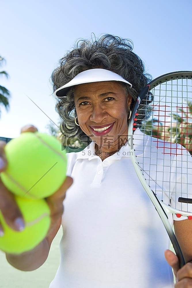 高龄女子手持网球拍和球，肖像